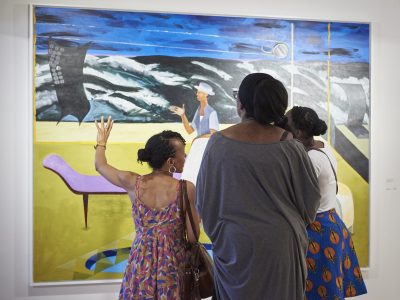 three people in front of a painting