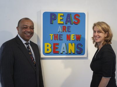 Man and woman standing in front colourful text painting