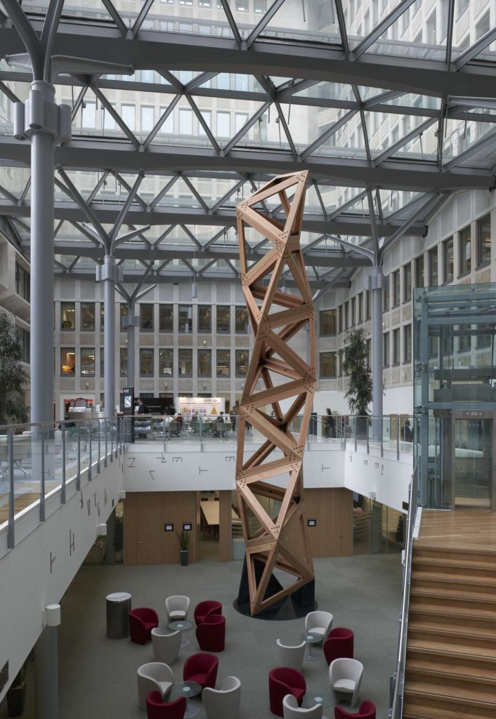 an atrium with a large sculpture made of wood