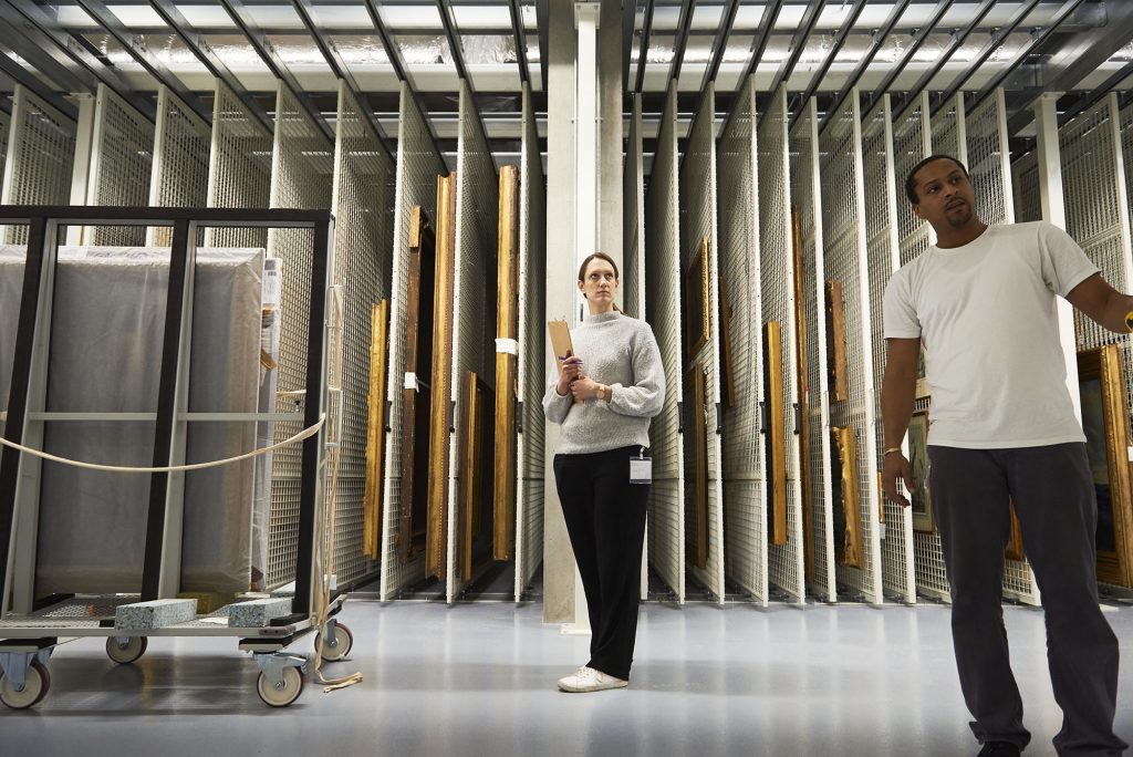 interior of an art store with two people checking works of art