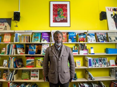 An artist standing in front of his work in a library