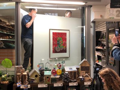 A man installing a print in a shop window